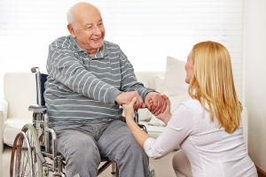 Woman holding hands of old man