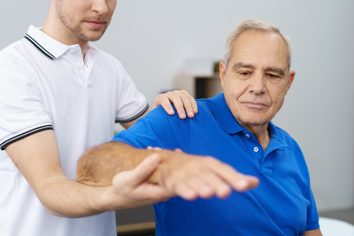 senior man receiving a treatment of his shoulder and arm