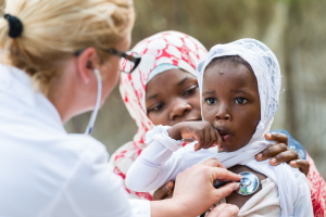 Mother holding her child while the nurse checking the heartbeat