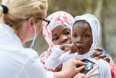 mother holding her child while the nurse checking the heartbeat