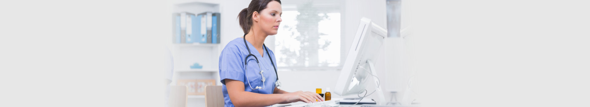 Side view of young female surgeon using computer