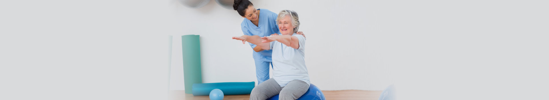 Happy nurse assisting senior woman in exercising