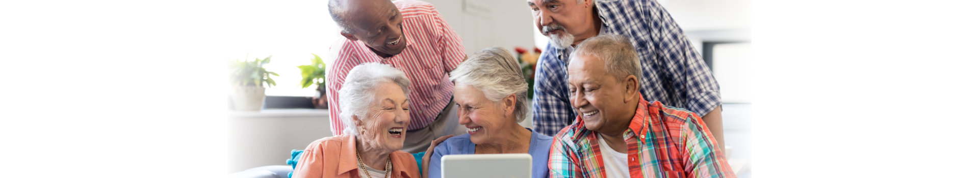 Senior woman showing digital tablet to cheerful friends